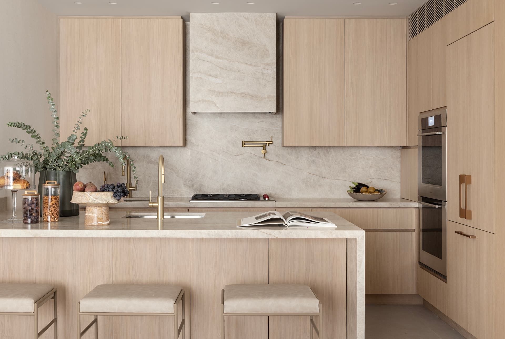 Kitchen with island, stone hood, and brass fittings