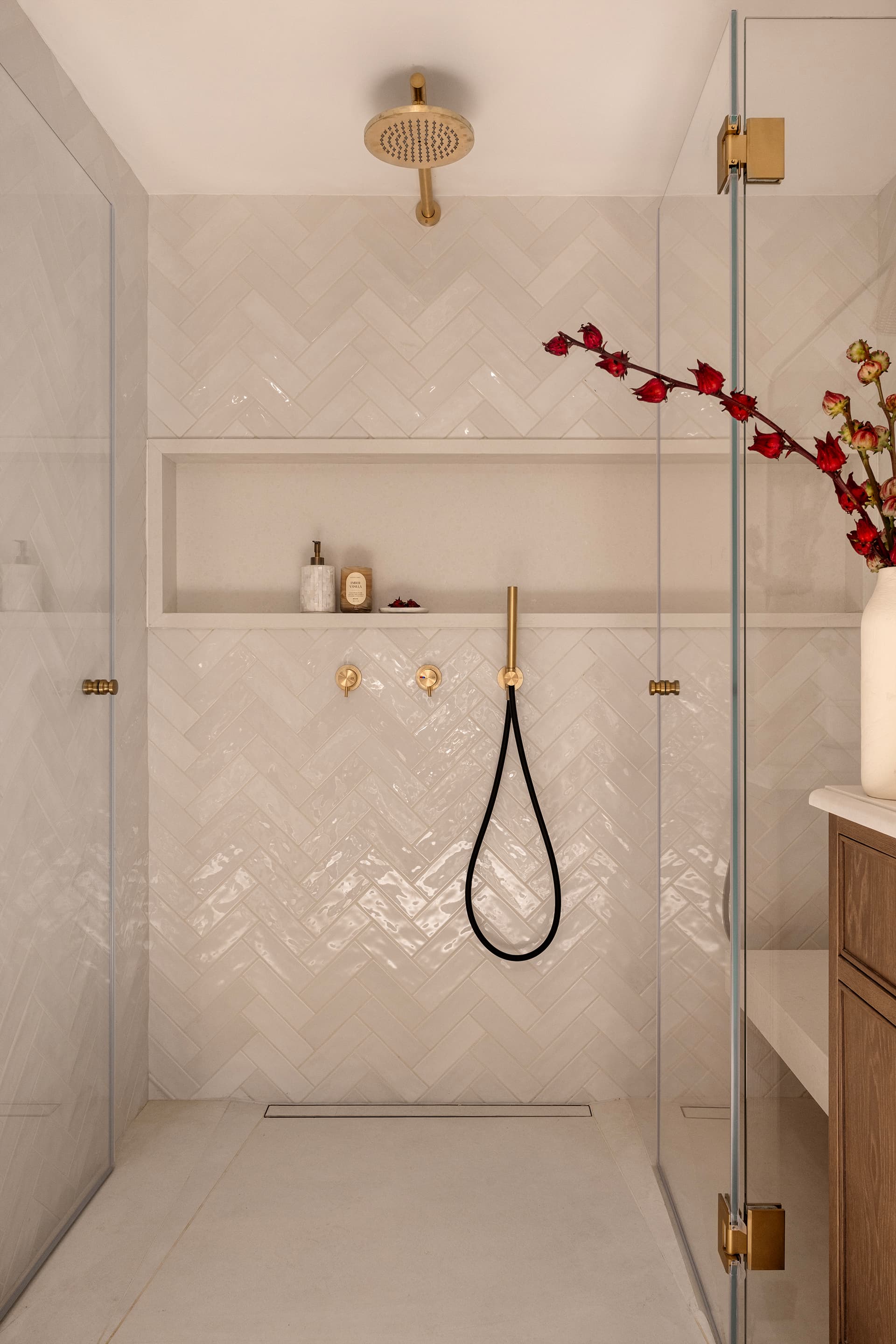Shower with herringbone tile and brass rainfall fitting