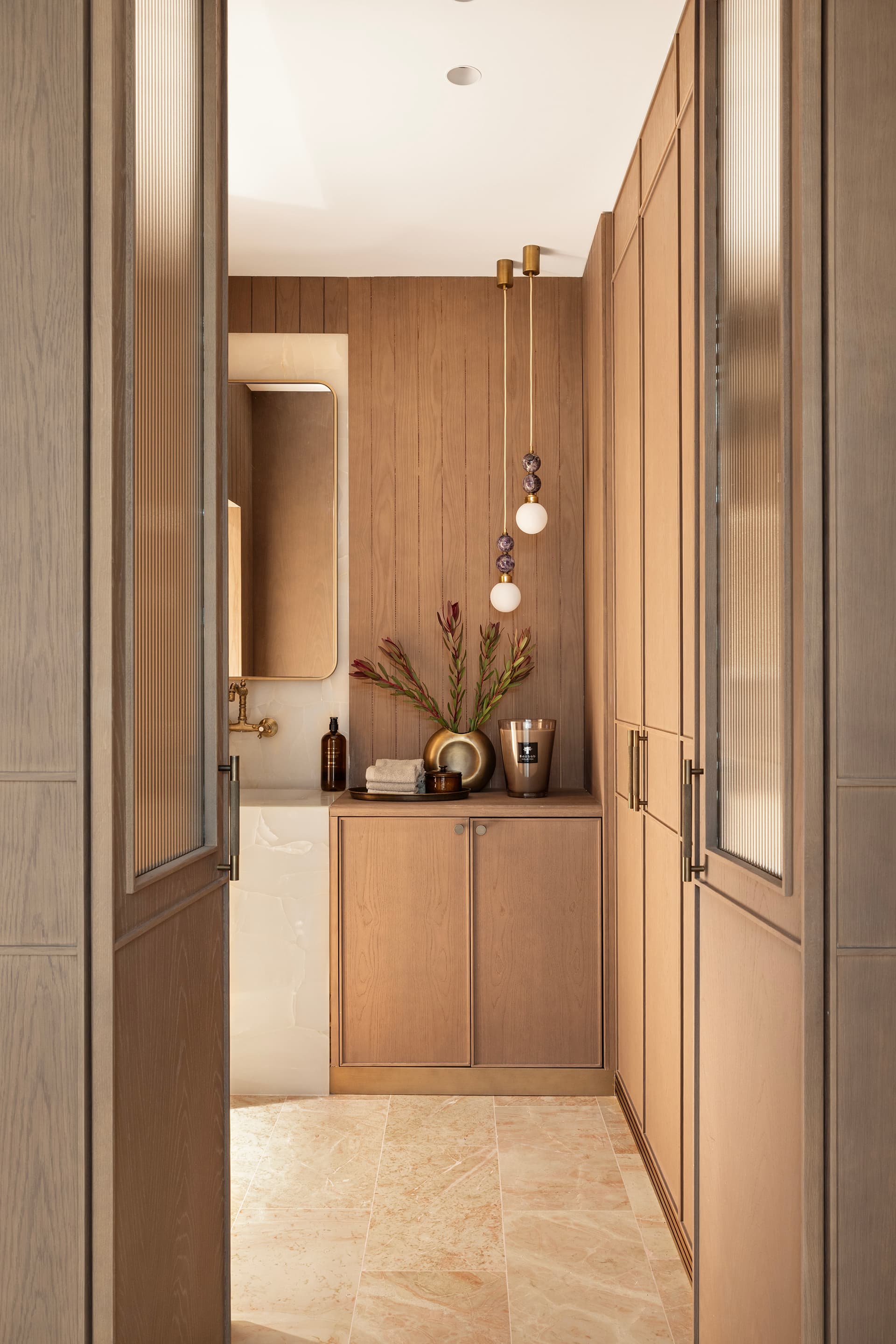 Dressing corridor glimpsed through oak millwork doors