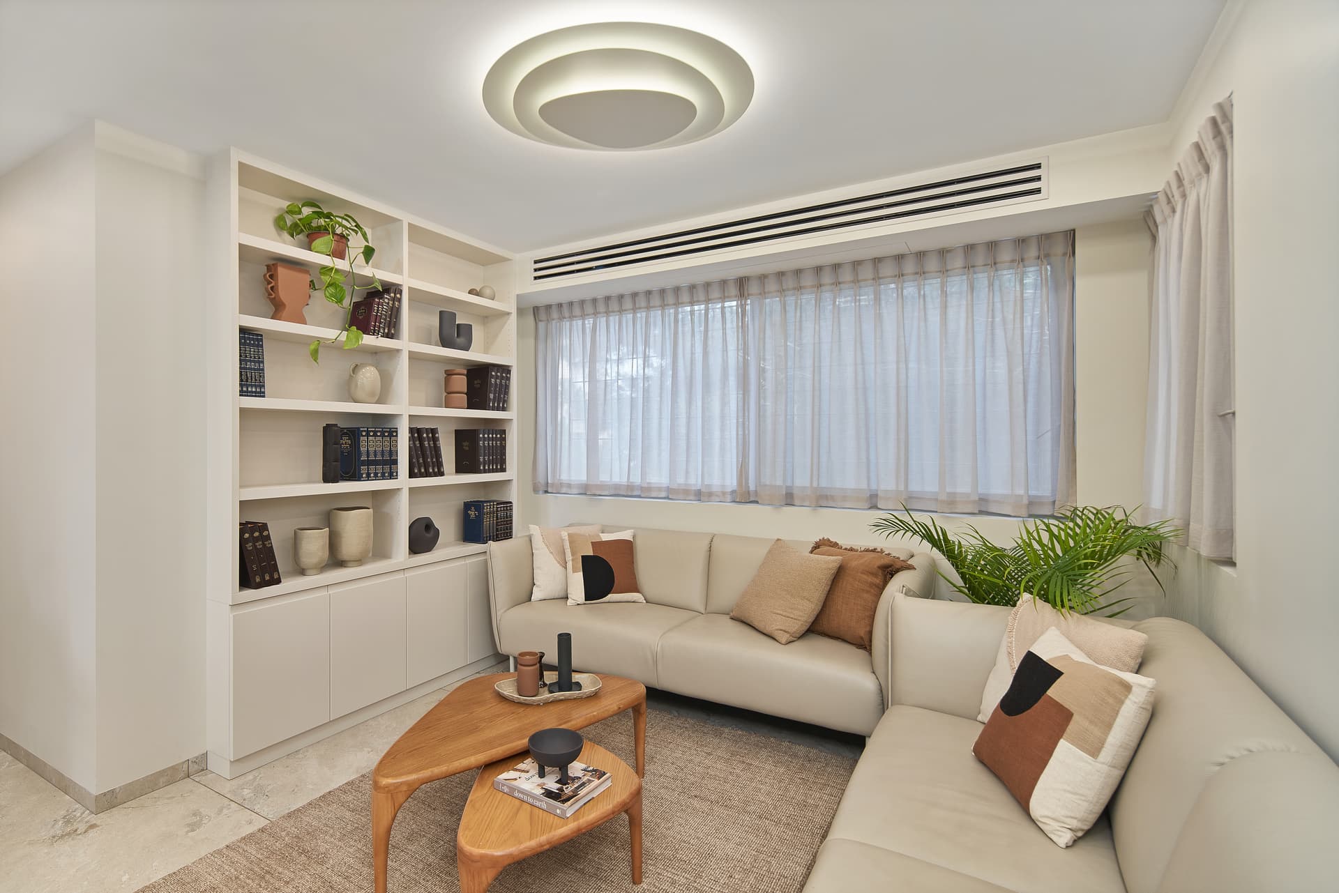 Living room with floor-to-ceiling built-in shelving and cream sectional sofa
