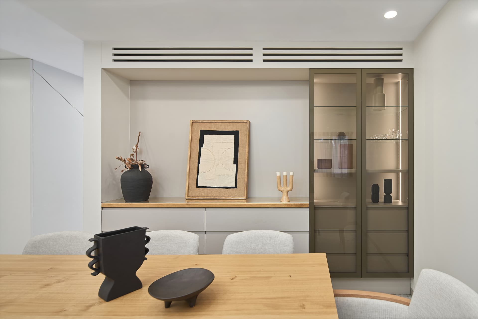 Built-in display niche with framed artwork and smoked glass cabinet