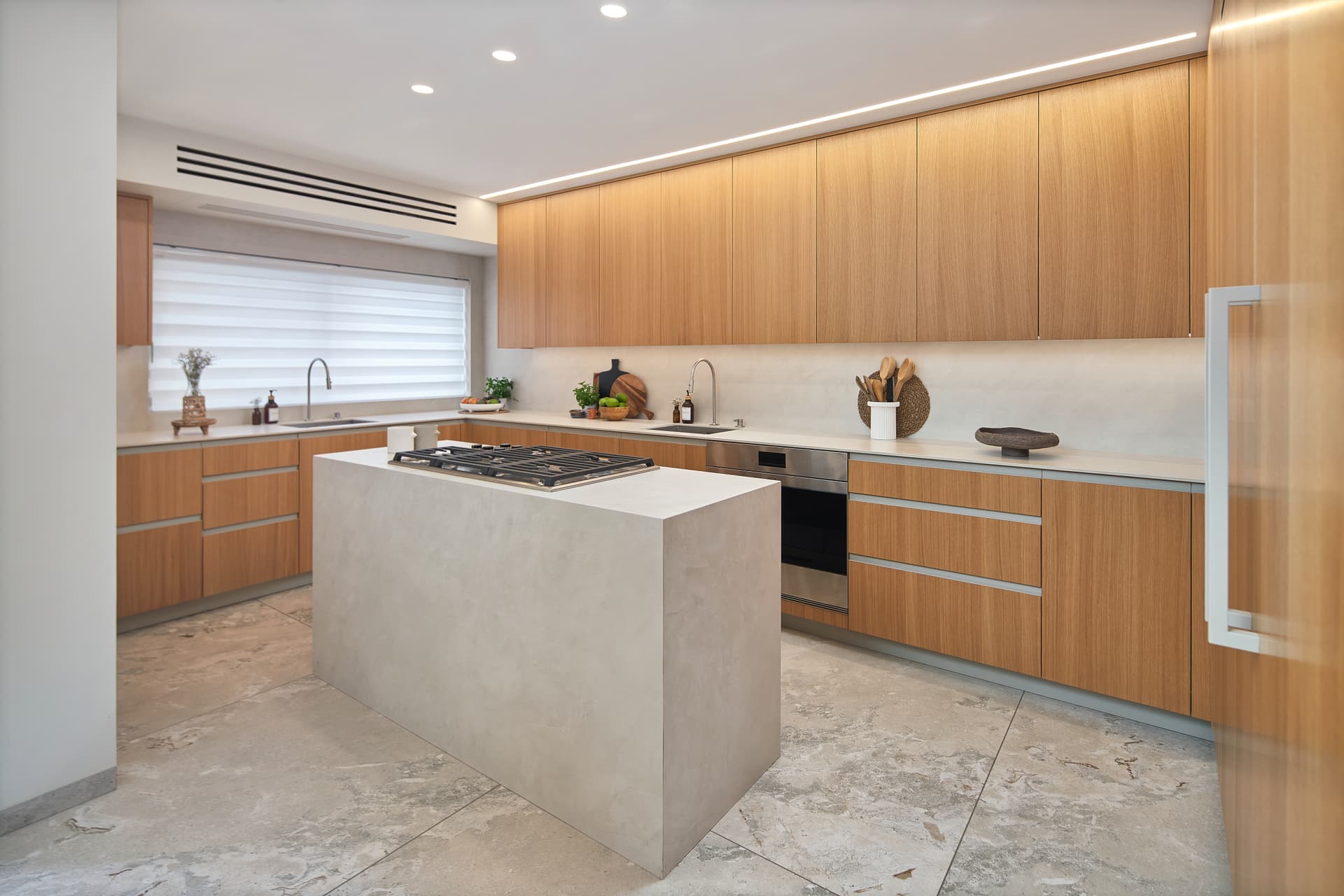 Open-plan living and dining room with travertine floors and oak shelving, Arzei HaBira Flat Jerusalem