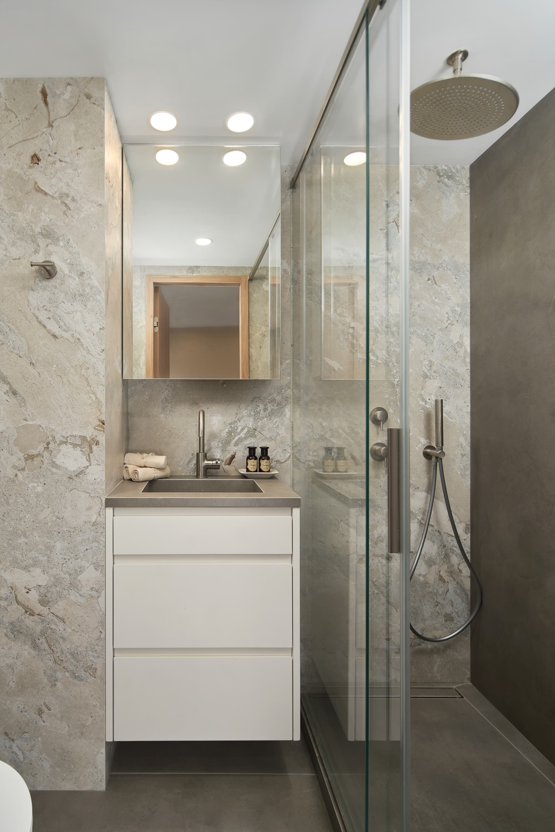 En-suite bathroom with full marble wall cladding and glass shower