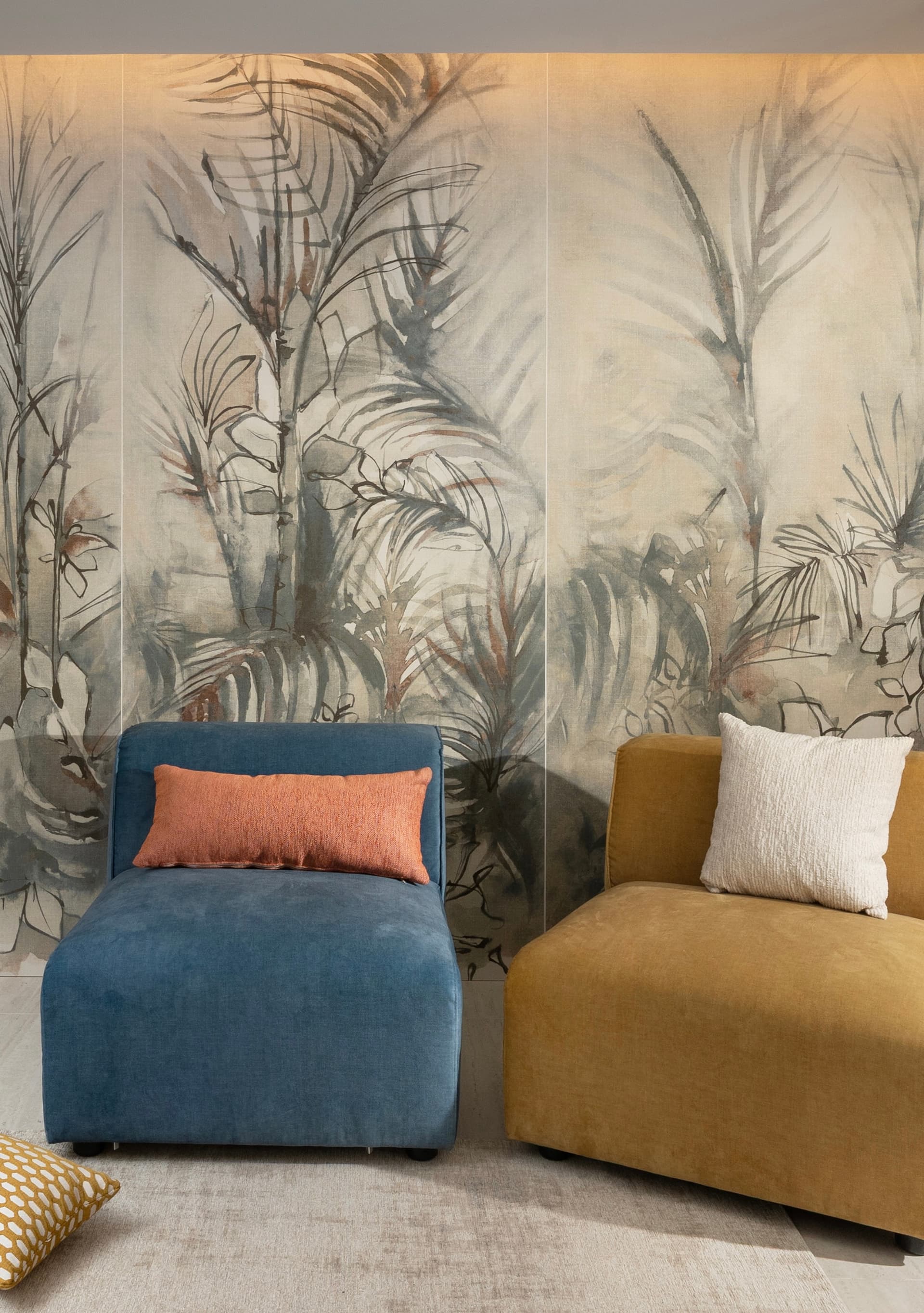 Lounge corner with watercolor palm wall covering and velvet chairs in blue and mustard