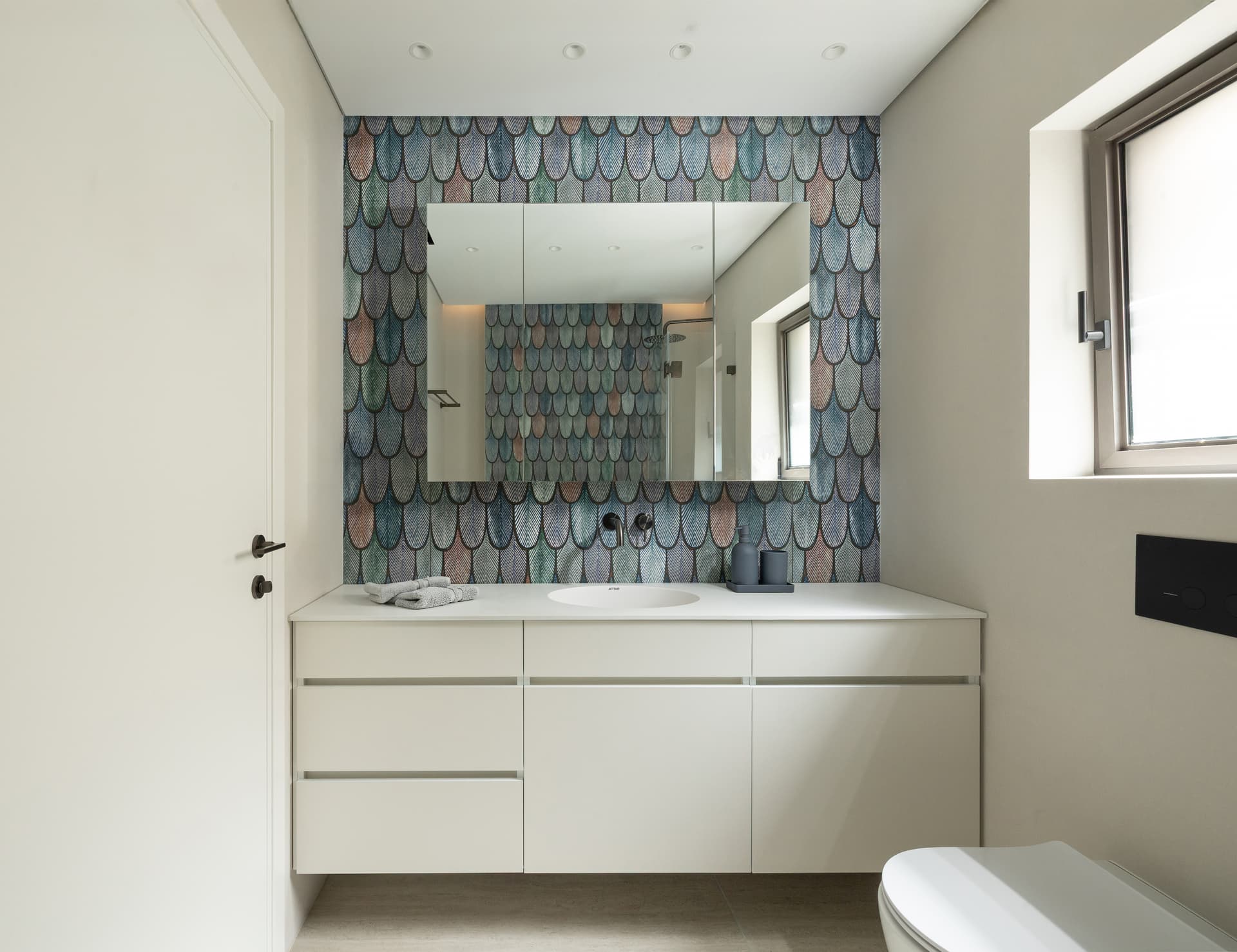 Family bathroom with blue fan-tile feature wall and white double vanity