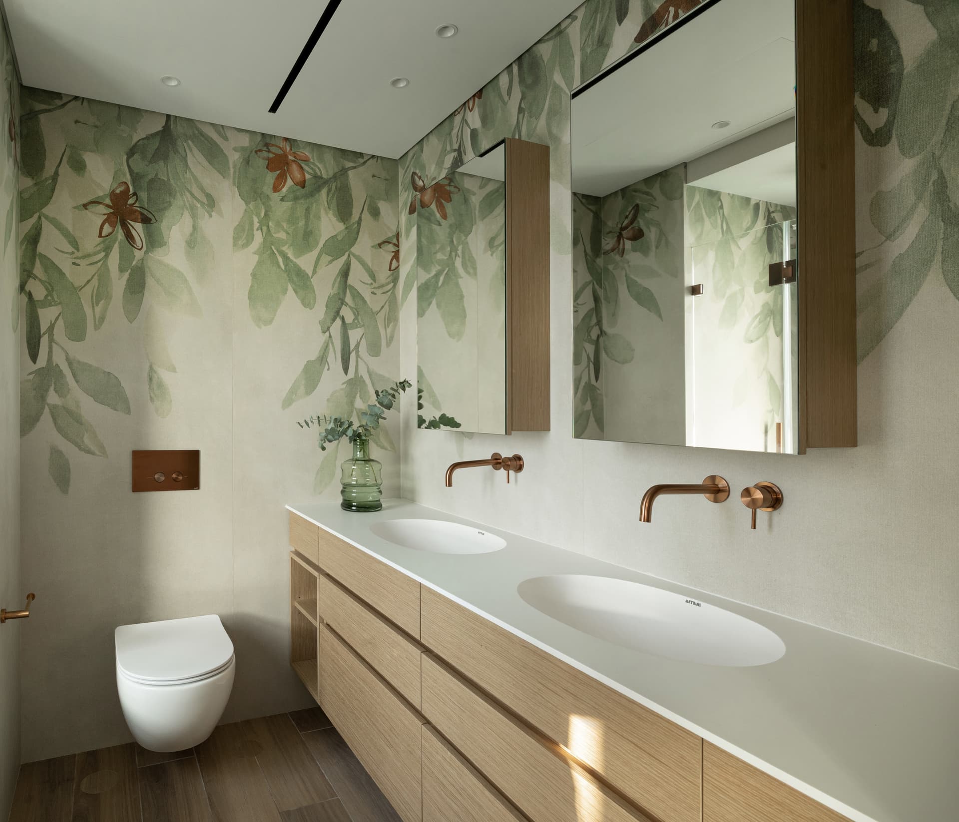 Master bathroom with floor-to-ceiling botanical-print walls, brass tapware, twin basins, and oak vanity